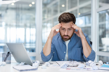 Portrait of upset frustrated financier working on paperwork in the middle of the office, man...