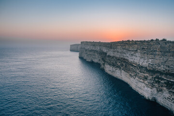 Aerial panoramic scenic sunset viewpoint over high Ta Cenc cliffs and azure Mediterranean Sea on a sunny day, Gozo Island, Malta, Europe