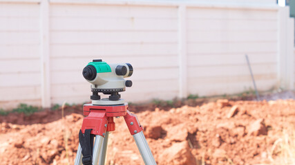 surveyor's telescope for measuring the height of areas in construction sites, houses, buildings, and equipment concepts for work The background is the wall and the ground.