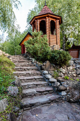 A stone staircase leads up to a wooden structure with a bell tower