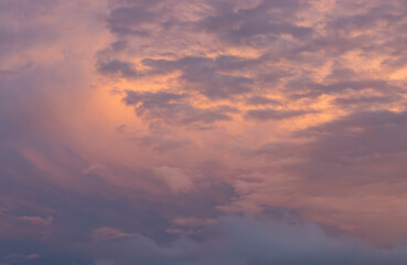 Obraz premium blue sky at dusk with a group of storm clouds in orange tones