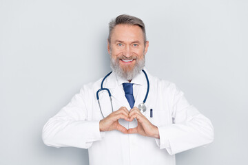Fototapeta premium Smiling senior male doctor wearing a white coat in a healthcare setting