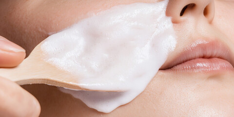Naklejka premium Facial Cleansing with Foaming Product and Wooden Spoon