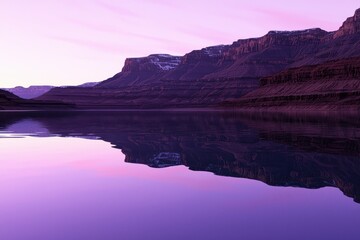 Naklejka premium A serene landscape featuring a calm lake reflecting purple hues and majestic mountains under a soft twilight sky.