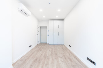 Modern Minimalistic Interior With Wood Flooring and Bright White Walls. AC on the Wall. Home Interior