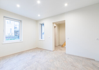 Modern New Construction Empty Room With Wooden Flooring and Large Windows Allowing Natural Light. Home Interior
