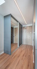 Modern Hallway Interior With Wooden Floor and Mirrored Wardrobe Sliding Doors. Home Interior