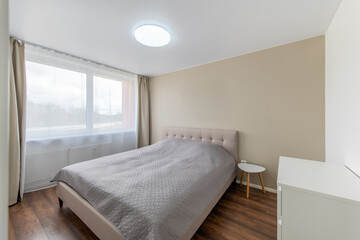 Minimalism Children, Young Adult Living Room Interior. Bed and Coffee Table. Gray Blanket on the Bed. Windows and Curtains. LED Light