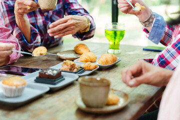 Senior Asian woman with close friend after retirement enjoying pastries and drinks at cafe. Elderly friends sharing food, sipping tea, and celebrating their time together. Cozy atmosphere and happy