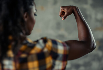 African American woman striking a strongman pose with her arm bent at the elbow. Back side view. International Women's Day, March 8 banner