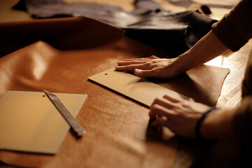 Hands of skilled artisan handling leather with precision, preparing for detailed craftsmanship....