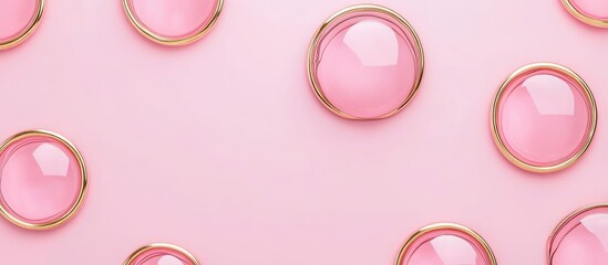 Soft pink and gold abstract seamless background featuring glossy circles on bubblegum pink surface with ample space for text insertion