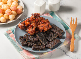 Fried Chicken thigh steak rice blood cake and potato balls served in plate with fork isolated on napkin side view of taiwan food