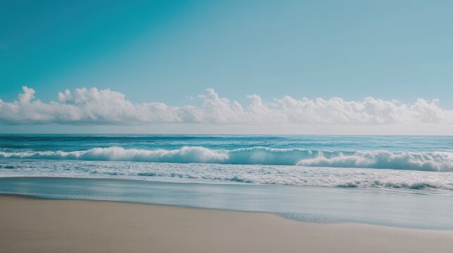 Serene coastal landscape featuring azure ocean waves lapping on a pristine sandy beach under a clear blue sky with fluffy white clouds.