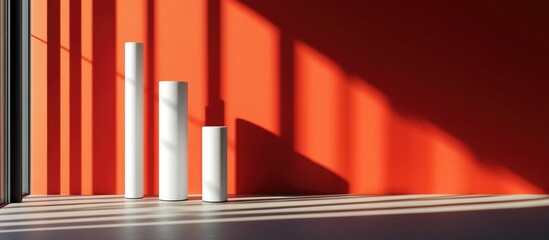 Fototapeta premium Minimalist design featuring white tubes against a vibrant red wall with dramatic shadows and ample copyspace for branding and messaging
