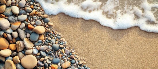 Beach Pebbles on Sandy Shoreline with Gentle Waves Creating a Serene Summer Vacation Atmosphere and Space for Text Use