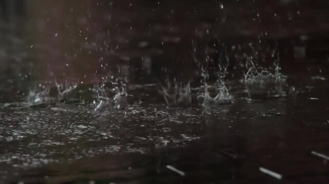 Drops of Rain Fall on the Sidewalk. Drops of rain fall from the roof onto a granite paving slab
