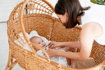 mom puts the baby to sleep in a bright bedroom, healthy baby sleep