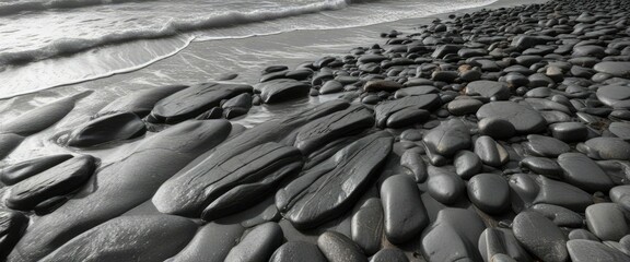 Fototapeta premium Grayscale wave pattern on a rocky beach at low tide , water, shoreline