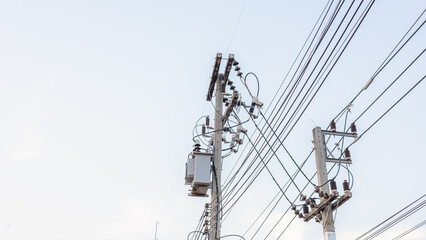 Electrical energy transfer distribution on concrete pole against white sky background, AC...