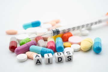AIDS Acquired immunodeficiency syndrome word with pills and capsules medical drug.