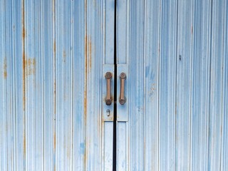 Fototapeta premium Folding gate iron door rolling door for shop or office doors. Blue colored steel rolling door, stripe texture