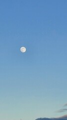 Rising moon on a full moon in a blue sky at sunset