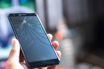 Smart phone with Cracked Screen Held in Hand