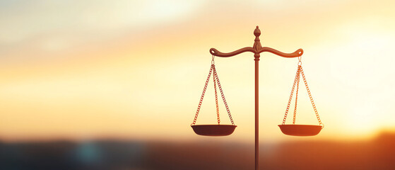 Balanced scale silhouetted against vibrant sunset, symbolizing justice and equality.