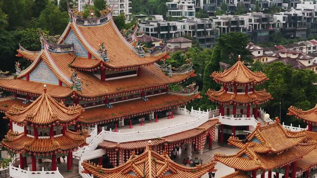 Traditional chinese temple roof architectural elements featuring ornate dragon sculptures, hanging lanterns, intricate wood carvings at kek lok si temple, penang
