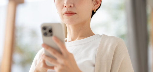 真剣な眼差しでスマホを見る女性