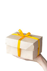 woman's hand holding a kraft cardboard box natural color, woman holding boxes with yellow gift ribbon or wrapping. gift or food delivery