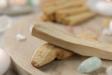 Palo santo sticks and gemstones on table, closeup