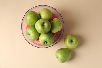 Kitchen scale with apples on beige background, top view