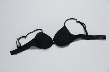 Beautiful black bra on white background, top view
