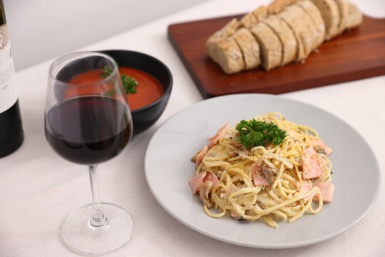 A delicious gourmet plate of Italian spaghetti pasta with tomato sauce, garnished with fresh green basil and cheese for a healthy restaurant lunch or dinner dish
