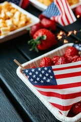 Obraz premium A festive spread featuring strawberries and raspberries adorned with small American flags, perfect for a patriotic celebration.