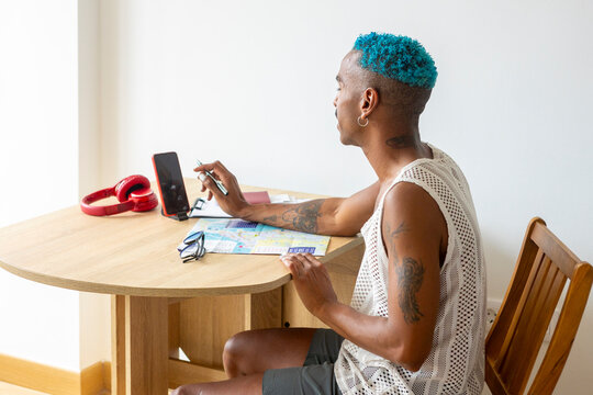 LGBTQIA+ person plans holidays with map and smartphone