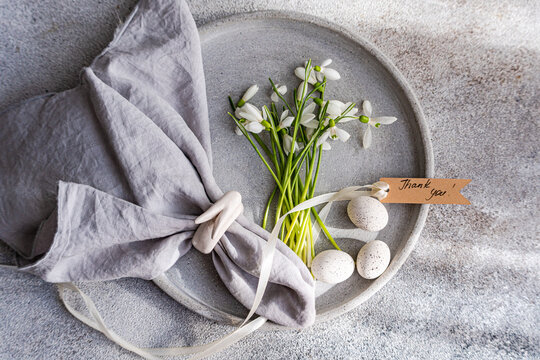 Elegant spring table setting with snowdrops and quail eggs