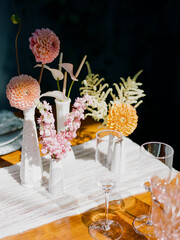 Elegant floral arrangement on wooden table enhances dining experience during afternoon gathering