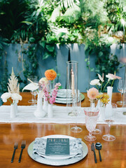 Elegant table setting with diverse floral arrangements in a lush garden during a sunny afternoon gathering