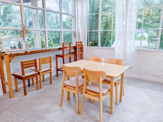 Bright and Airy Dining Room with Wooden Furniture and Large Windows Overlooking Lush Greenery