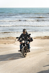 Bikers riding motorcycle on beach road enjoying sunny day