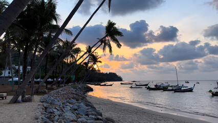 Trip to Thailand. Travel photo. Sea, sun, beach, island.
Summer vacation. Boat, yacht on water.
Sunset, palm tree, shore.