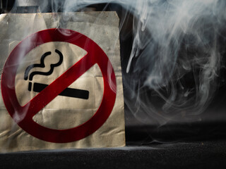 Smoke in front of no smoking sign