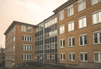 modern brick building with glass entrance and overcast sky.