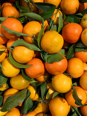 Mandarins or Tangerines with green leaves on display in top view at the vegetable shop