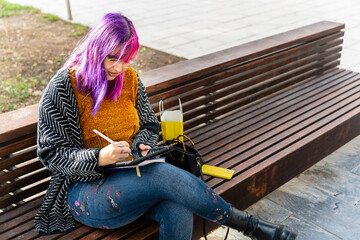 Body positive designer drawing on tablet sitting on bench