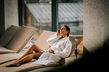 Woman enjoying a cocktail while relaxing in a luxurious spa setting during a tranquil afternoon