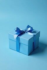 Obraz premium A Light Blue Gift Box with a Delicate Blue Ribbon Bow, Elegantly Presented on a Matching Background